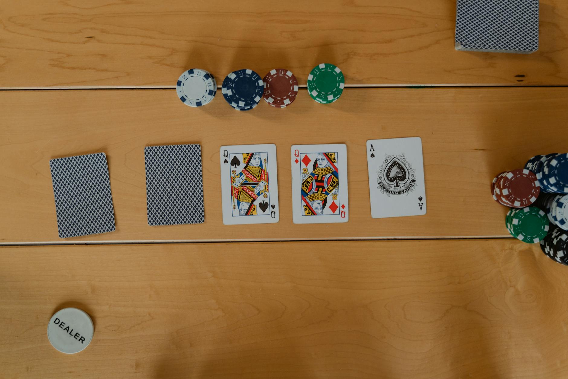 Các lá bài flop turn river bên cạnh chip poker thể hiện chiến thuật cược